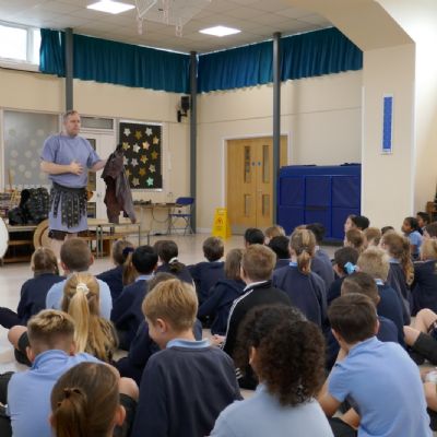 Ancient Greek presenter with the pupils in the foreground.